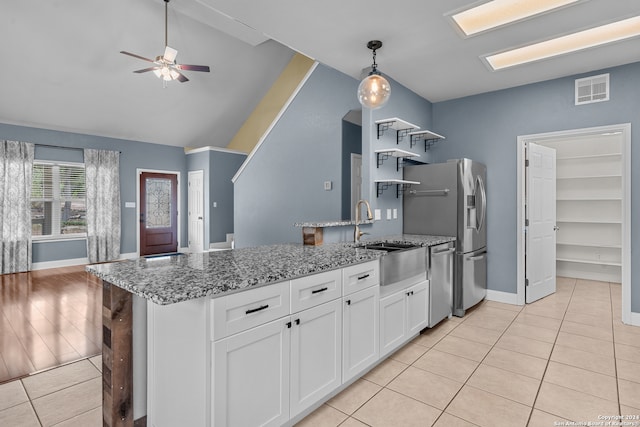 kitchen featuring light stone countertops, sink, light hardwood / wood-style floors, lofted ceiling, and white cabinets