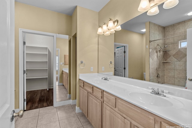 bathroom with vanity, toilet, tiled shower, and tile patterned flooring