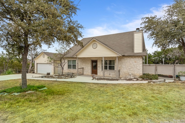 view of front of property with covered porch, a front yard, and a garage