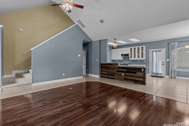 unfurnished living room with lofted ceiling, light wood-type flooring, and ceiling fan