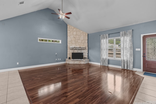 unfurnished living room with hardwood / wood-style floors, a fireplace, high vaulted ceiling, and ceiling fan