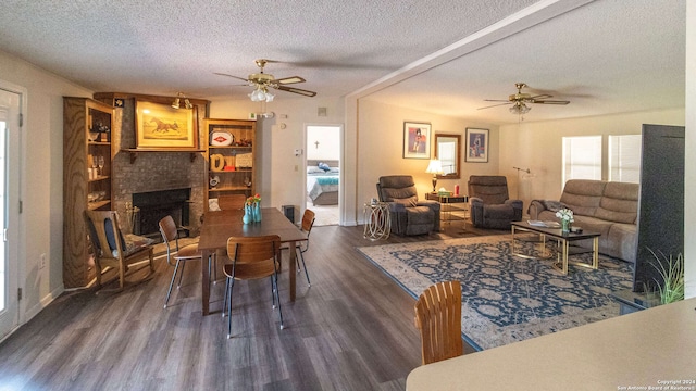 living room featuring a brick fireplace, a textured ceiling, ceiling fan, and dark hardwood / wood-style flooring