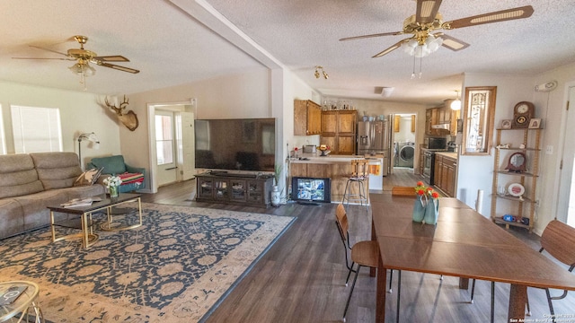 living room with dark wood-type flooring, ceiling fan, a textured ceiling, and washer / dryer