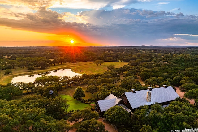 aerial view at dusk featuring a water view