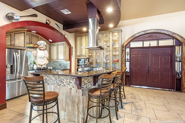 kitchen with tasteful backsplash, island range hood, a kitchen bar, stainless steel appliances, and a center island