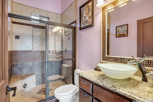 bathroom featuring vanity, an enclosed shower, and toilet