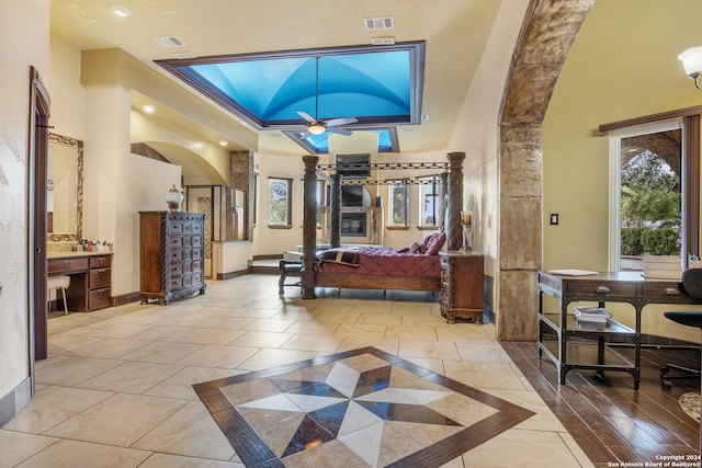 bedroom with lofted ceiling, connected bathroom, and ornate columns