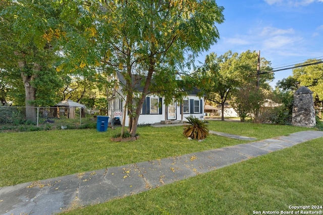 view of property hidden behind natural elements featuring a front yard