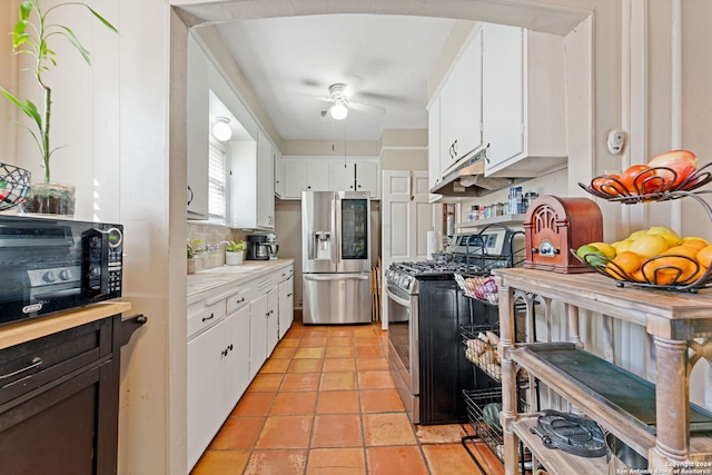 kitchen featuring decorative backsplash, white cabinetry, stainless steel appliances, and ceiling fan