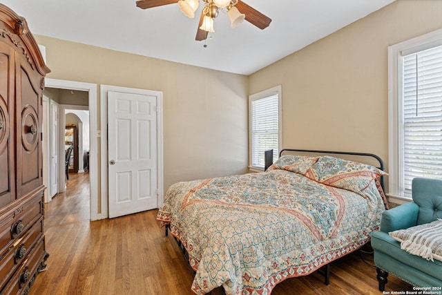 bedroom with multiple windows, hardwood / wood-style floors, and ceiling fan