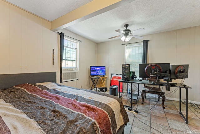 bedroom featuring beam ceiling, ceiling fan, cooling unit, a textured ceiling, and wooden walls