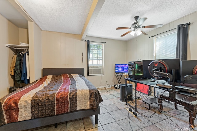 bedroom with a closet, ceiling fan, a textured ceiling, and light tile patterned floors