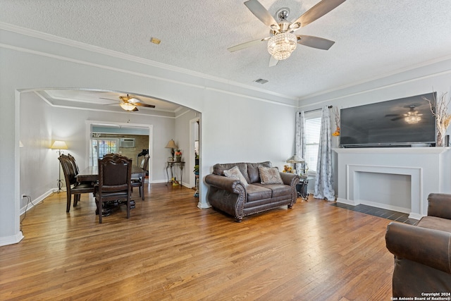 living room featuring crown molding, hardwood / wood-style flooring, a textured ceiling, and ceiling fan