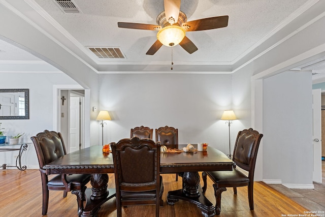 dining space featuring crown molding, hardwood / wood-style floors, a textured ceiling, and ceiling fan