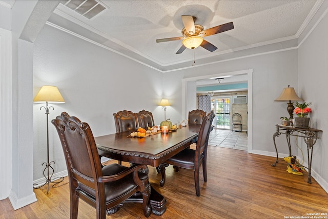 dining area with ornamental molding, a textured ceiling, and hardwood / wood-style flooring