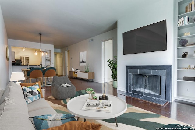 7707 Broadway Unit 9, San Antonio, TX 78209 - unfurnished living room featuring baseboards, visible vents, wood finished floors, and a fireplace