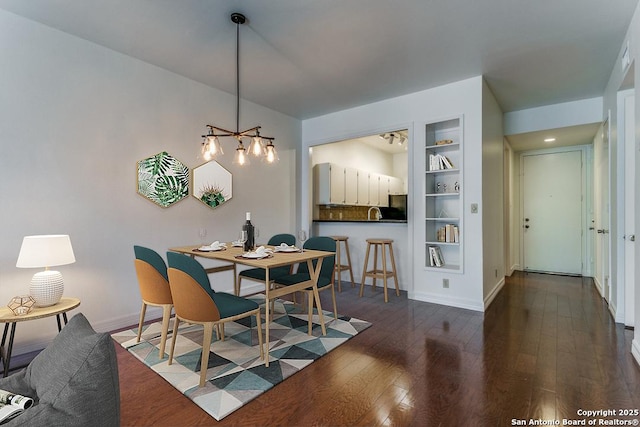 7707 Broadway Unit 9, San Antonio, TX 78209 - interior space featuring built in features, dark wood-style flooring, baseboards, a chandelier, and a sink