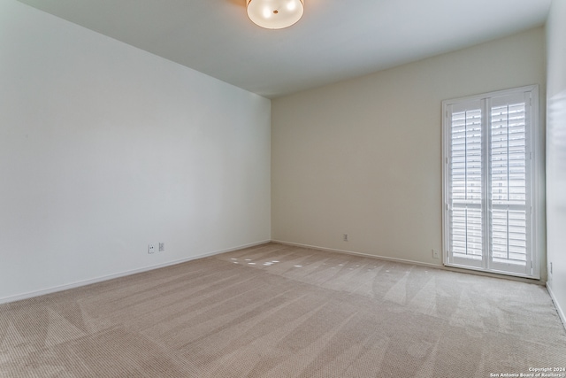 spare room with light carpet and plenty of natural light