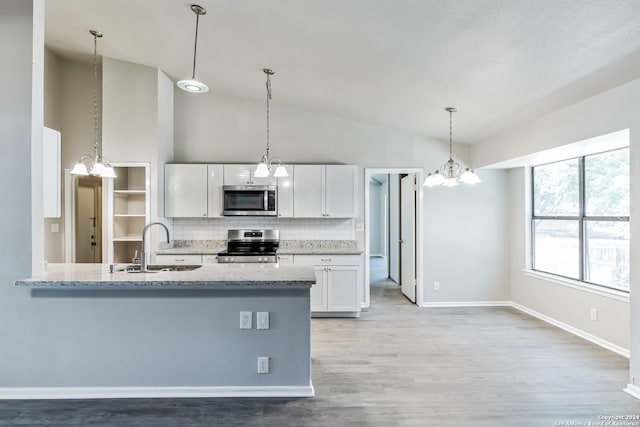 kitchen with hardwood / wood-style flooring, sink, light stone countertops, white cabinets, and appliances with stainless steel finishes