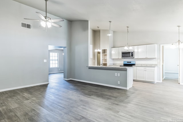 kitchen featuring kitchen peninsula, stainless steel appliances, white cabinets, dark wood-type flooring, and high vaulted ceiling