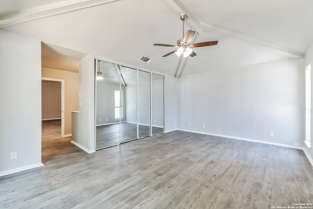 unfurnished bedroom with a closet, light wood-type flooring, vaulted ceiling with beams, and ceiling fan