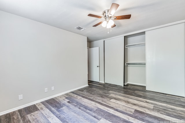 unfurnished bedroom with dark hardwood / wood-style floors, a closet, and ceiling fan