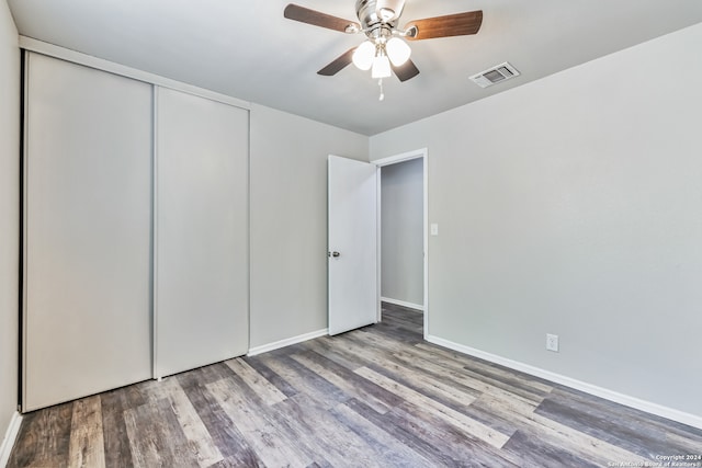 unfurnished bedroom with wood-type flooring, a closet, and ceiling fan