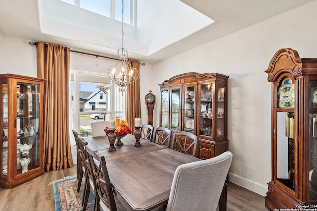 dining area featuring hardwood / wood-style flooring, a chandelier, and a tray ceiling