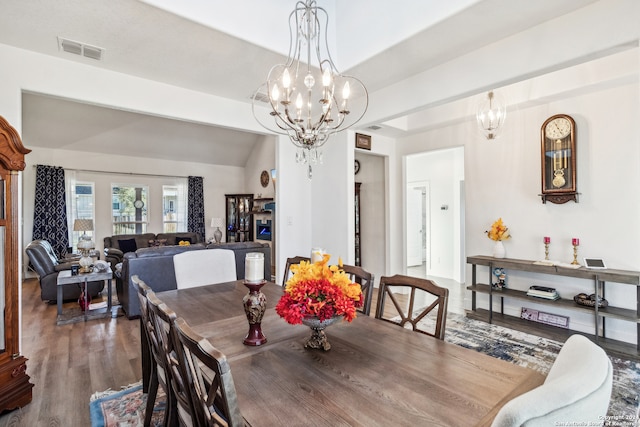 dining room with vaulted ceiling, a notable chandelier, and hardwood / wood-style flooring