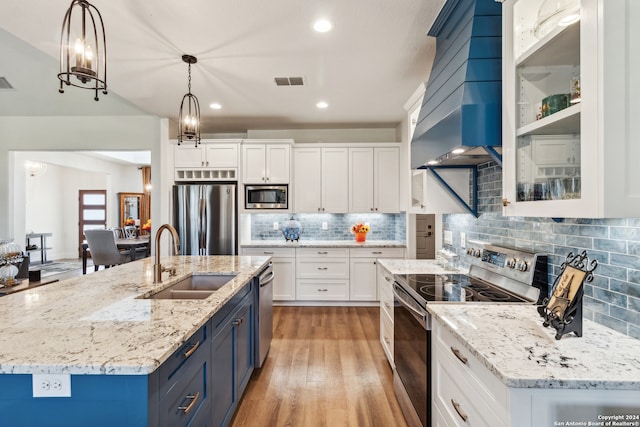 kitchen featuring hanging light fixtures, sink, white cabinetry, blue cabinets, and appliances with stainless steel finishes