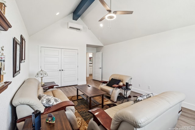 living room with beamed ceiling, a wall mounted AC, light hardwood / wood-style floors, and ceiling fan