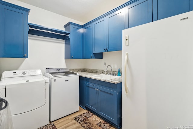 laundry area with sink, separate washer and dryer, light hardwood / wood-style floors, and cabinets