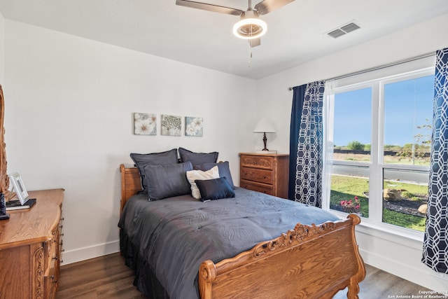 bedroom with dark wood-type flooring, multiple windows, and ceiling fan