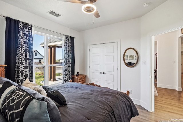 bedroom featuring a closet, multiple windows, light hardwood / wood-style floors, and ceiling fan