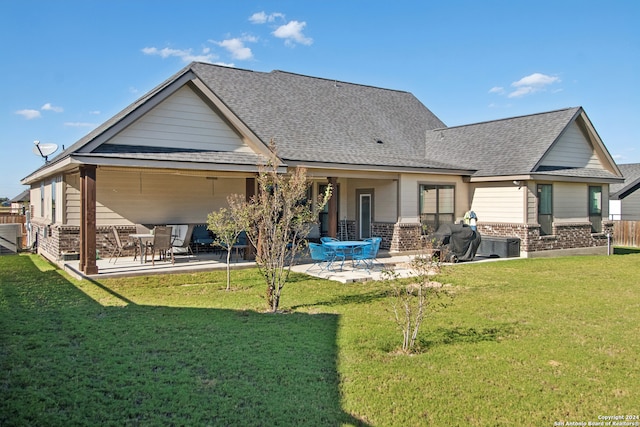 back of house with a patio and a lawn