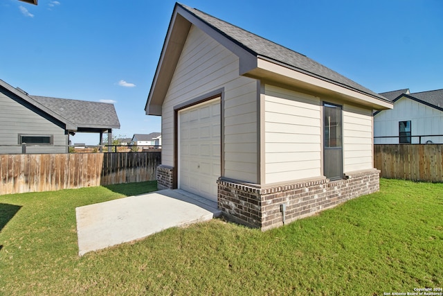 view of outdoor structure with a yard and a garage