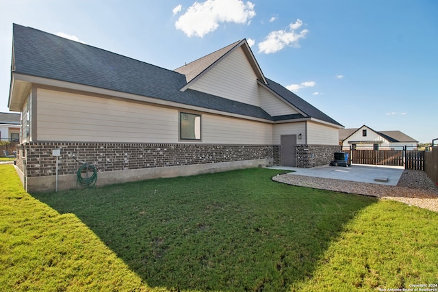 rear view of property with a yard and a patio area