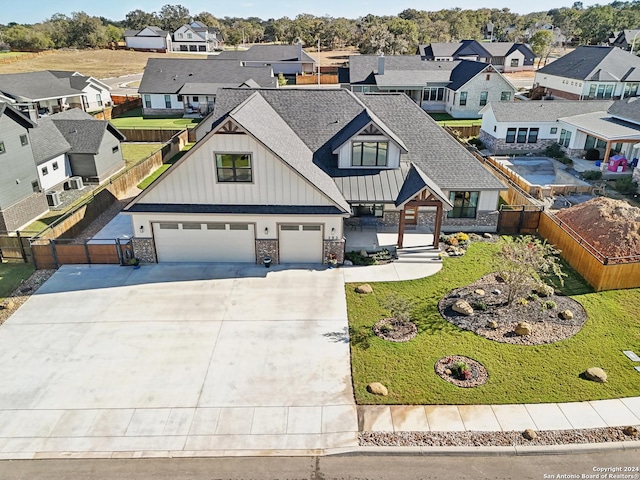 153 W Magnolia Cir, La Vernia, TX 78121 - view of front facade with board and batten siding, a residential view, concrete driveway, an attached garage, and fence