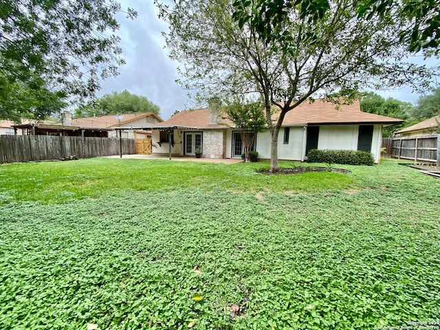 back of property featuring a yard and a patio area