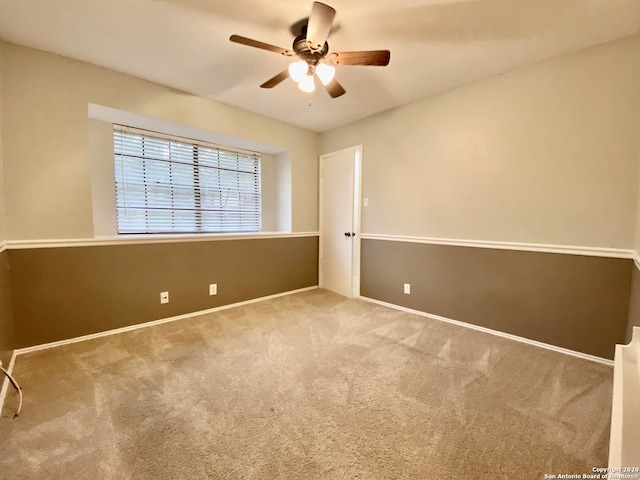 spare room with light carpet and ceiling fan