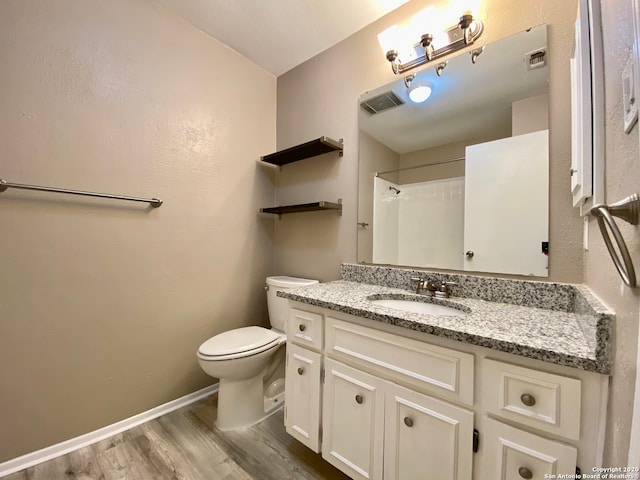 bathroom featuring toilet, a shower, vanity, and wood-type flooring