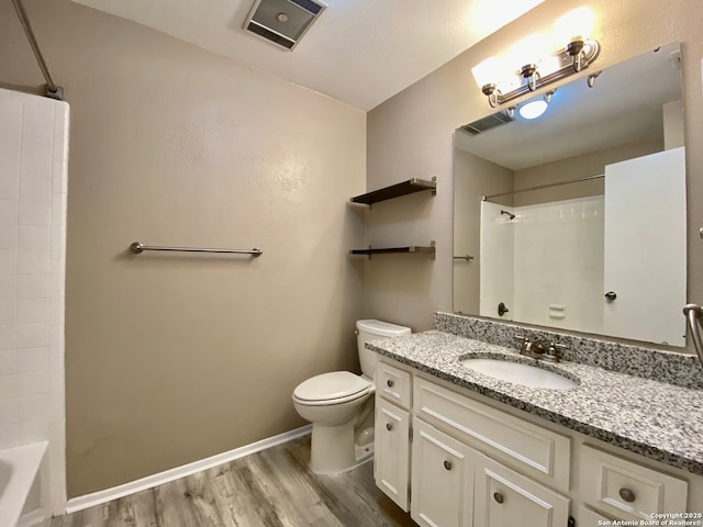 full bathroom featuring  shower combination, vanity, hardwood / wood-style floors, and toilet