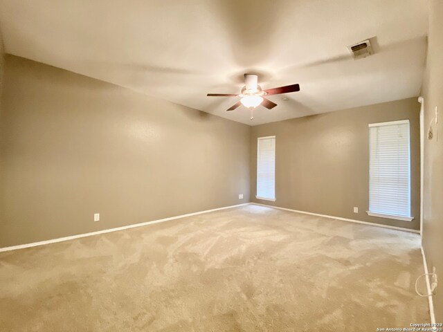 empty room with ceiling fan and carpet