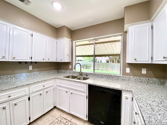 kitchen featuring white cabinetry, light stone countertops, dishwasher, light tile patterned flooring, and sink