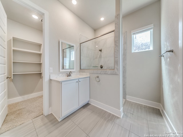 bathroom with a tile shower, tile patterned flooring, and vanity