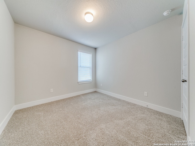 spare room with a textured ceiling and carpet