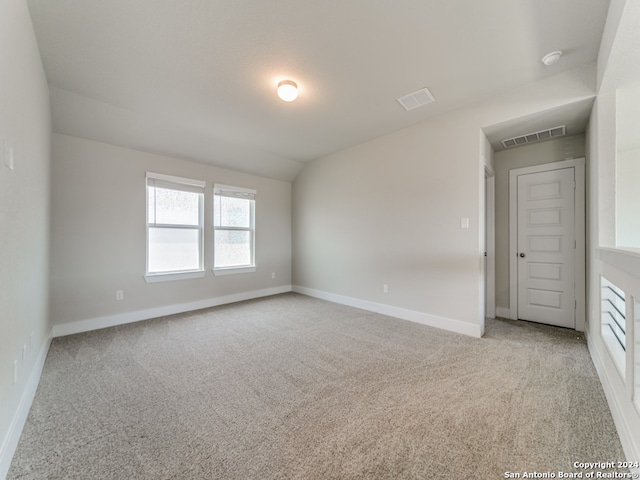 unfurnished room featuring carpet and vaulted ceiling