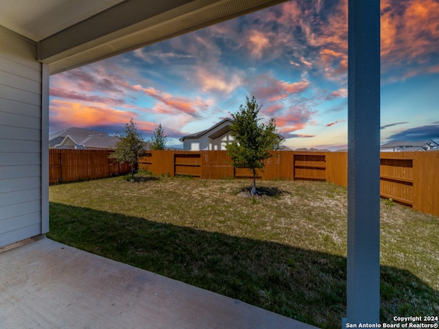 yard at dusk featuring a patio