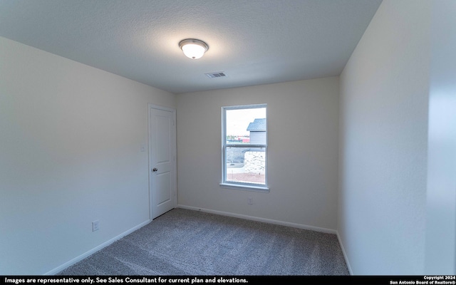 unfurnished room featuring a textured ceiling and carpet flooring