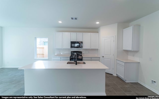 kitchen featuring white cabinets, black appliances, and an island with sink